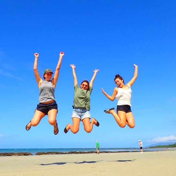 a woman jumping in the air on a beach