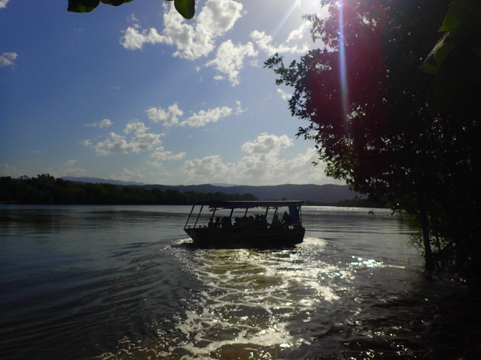a boat floating along a river next to a body of water