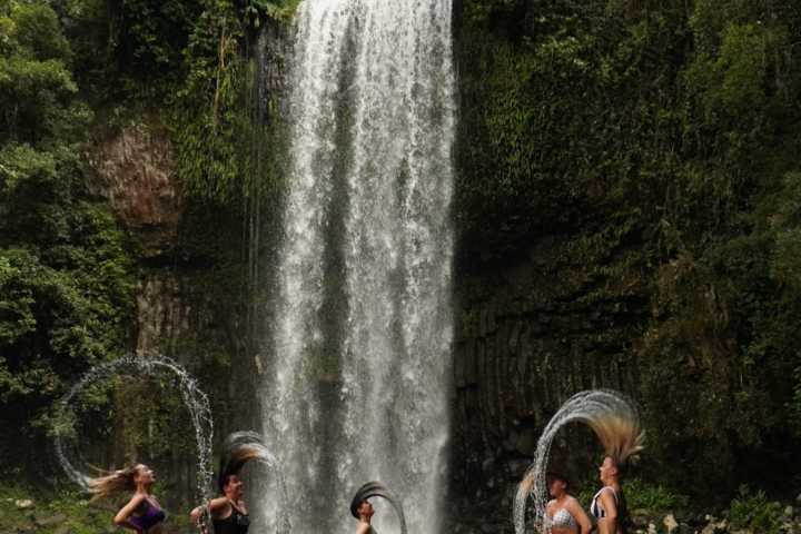 a group of people standing next to a waterfall